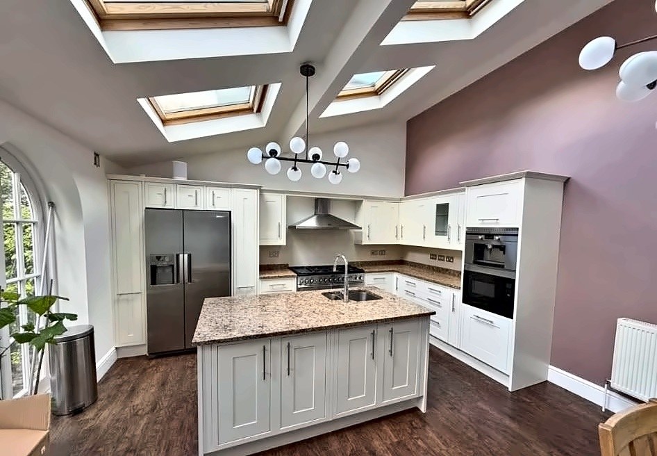 Cream shaker-style kitchen with granite island, professional appliances and garden access.